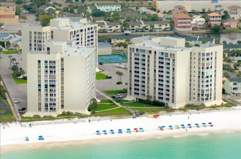 An aerial view of a white high-rise hotel on a sandy beach.