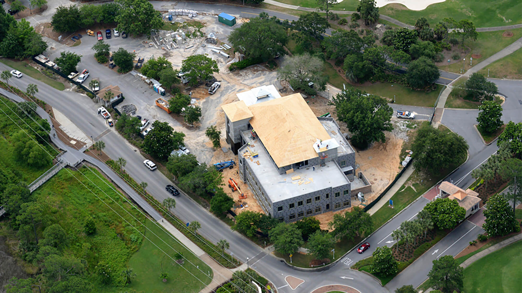 The steel frame of a multi-story building under construction, with a construction crane visible.