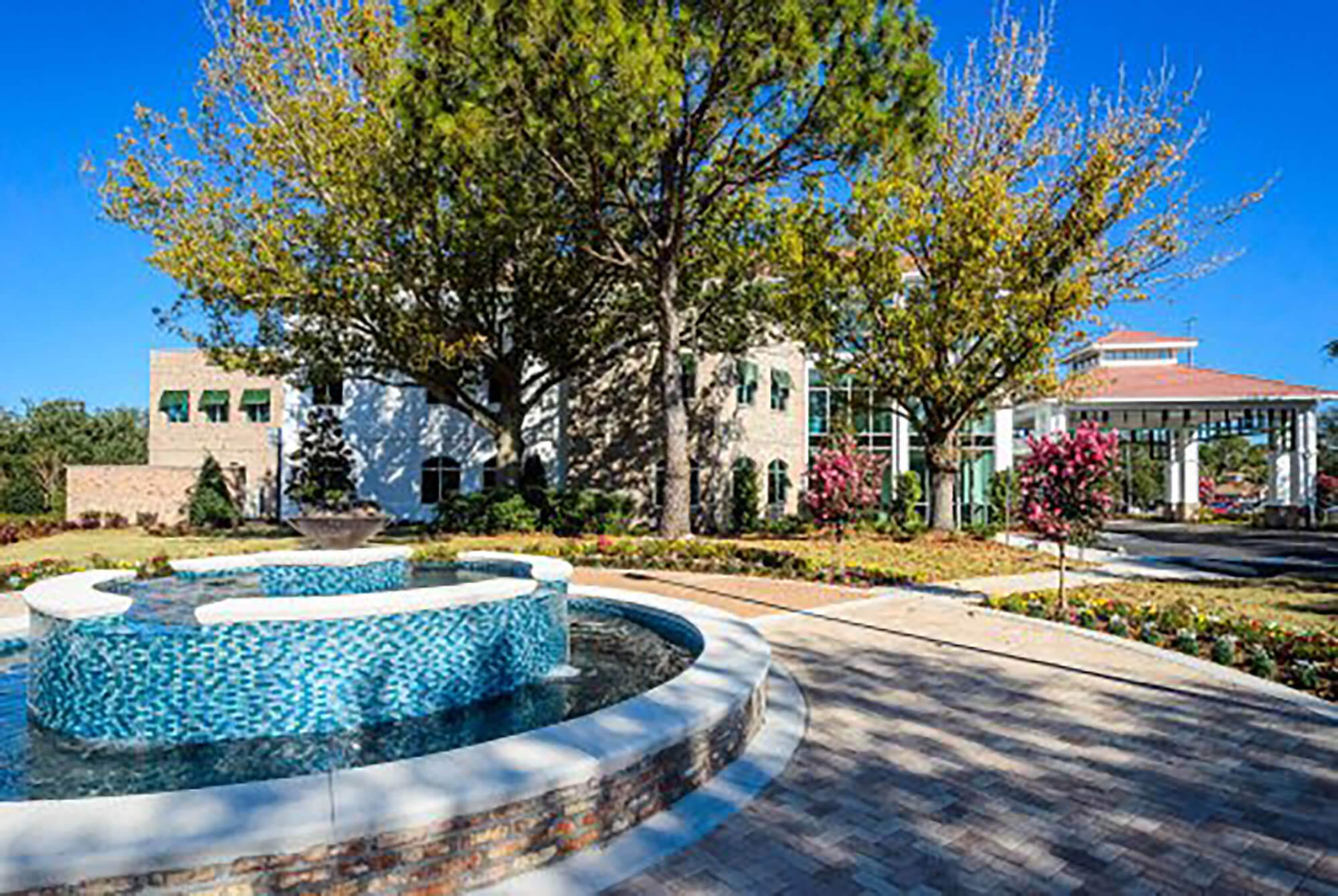 A fountain by a tree-lined terrace in front of the Sandestin Welcome Center