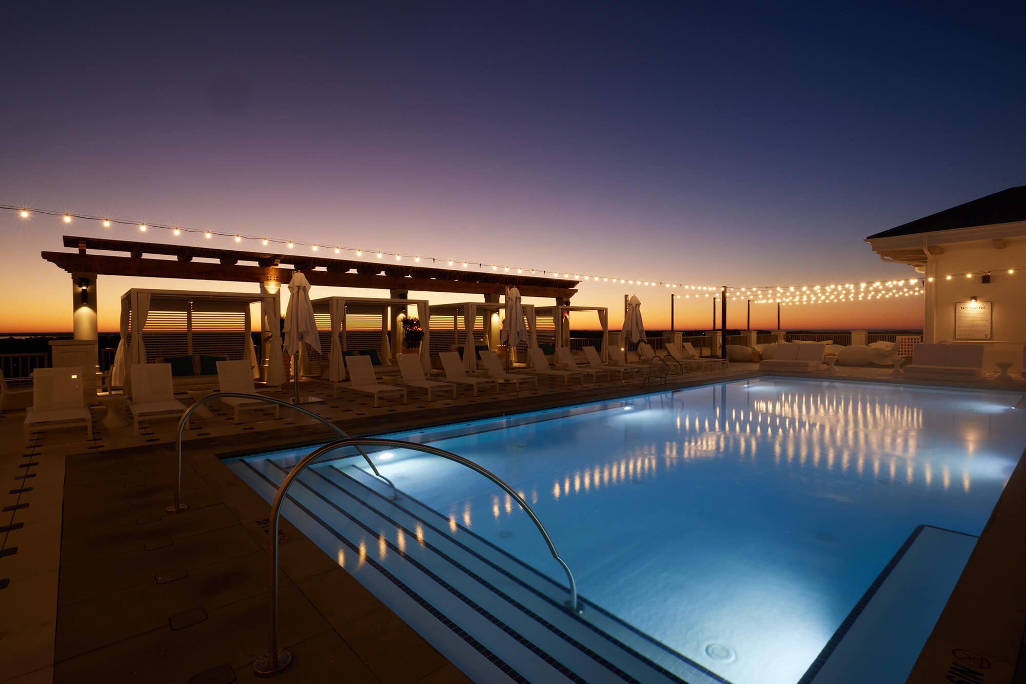 Hotel Effie's rooftop pool, illuminated at dusk