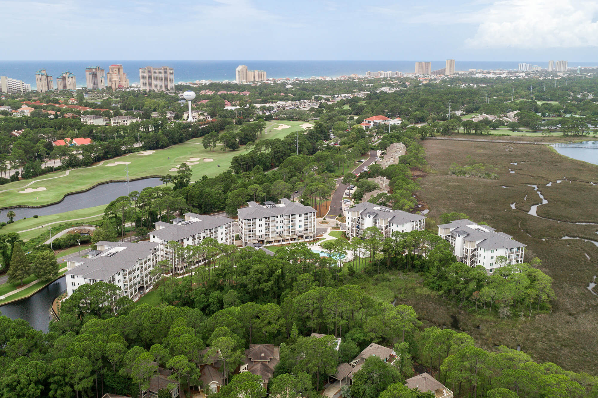 An aerial view of Osprey Pointe, in a wooding area abutting a golf course