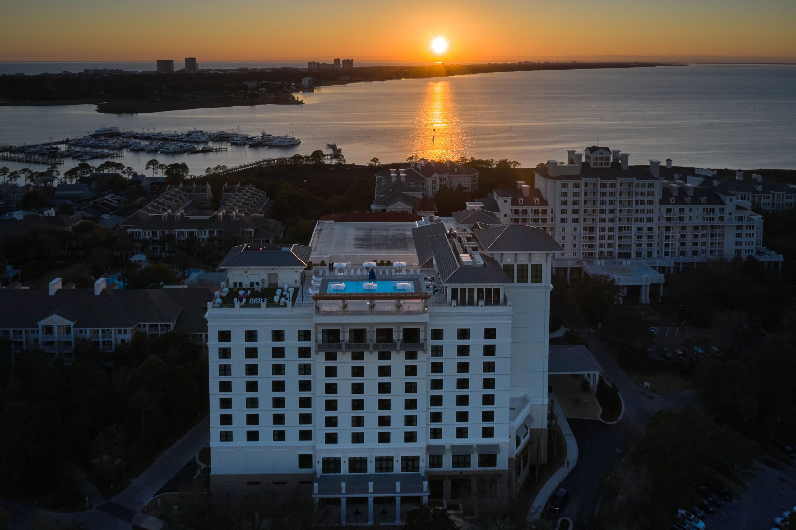 A view of the rooftop pool at the Hotel Effie at sunset, with water in the background.